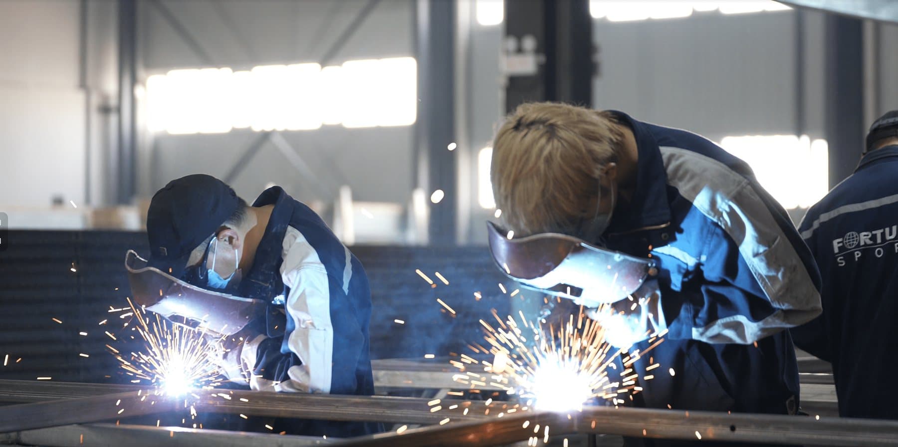 Welders assembling the steel structure of a padel court at the Fortune factory