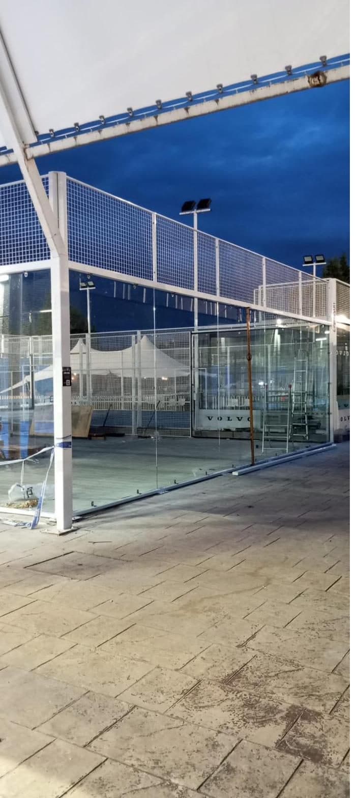 Detail of the galvanized steel post and tempered glass panel of a padel court